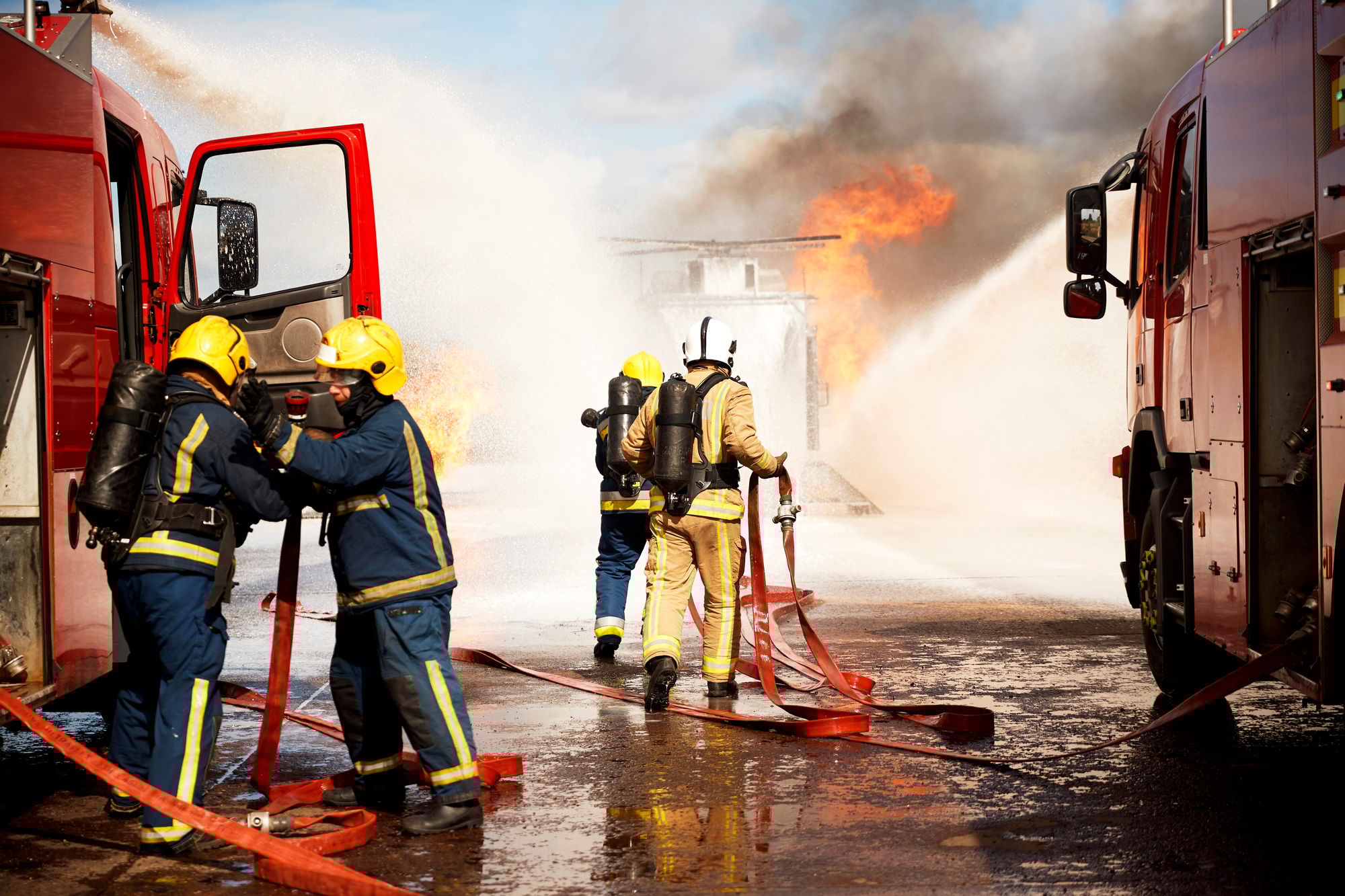 Firemen training, team of firemen extinguishing mock helicopter fire at training facility